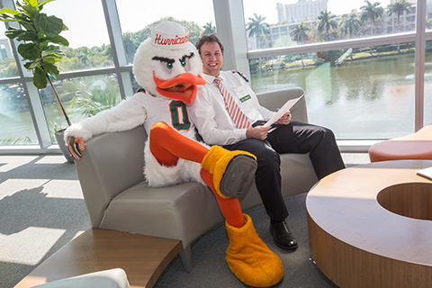 Sebastian the Ibis takes a picture with faculty in the Student Center